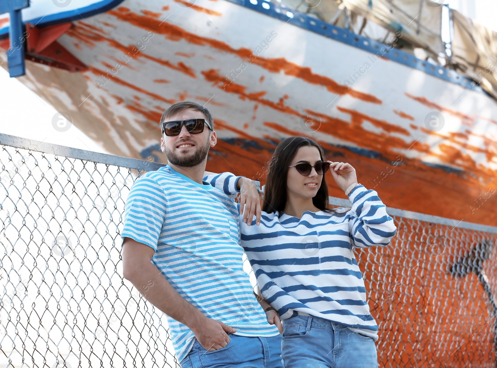 Photo of Young hipster couple in stylish jeans on pier