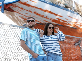 Photo of Young hipster couple in stylish jeans on pier