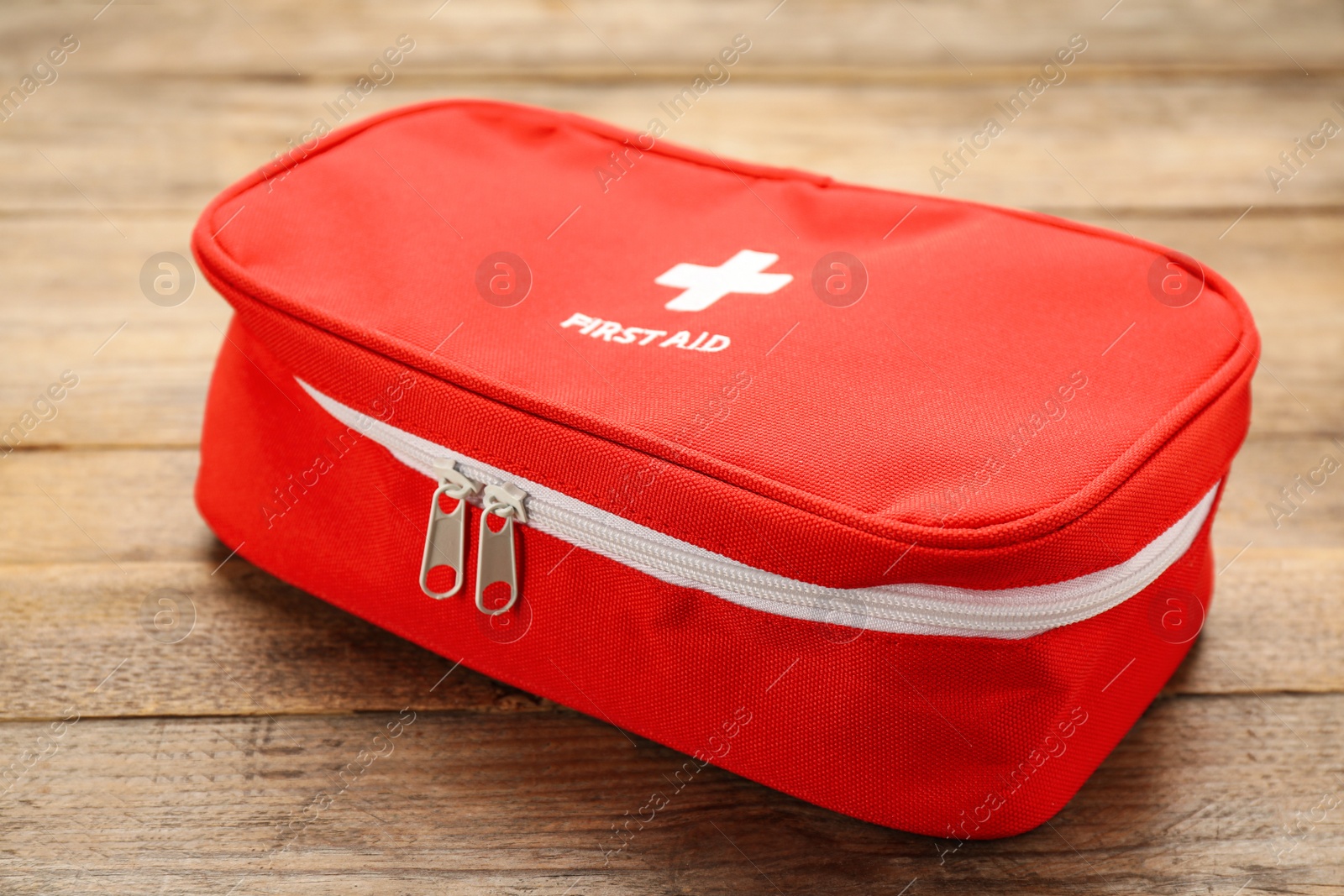 Photo of First aid kit bag on wooden table, closeup. Health care