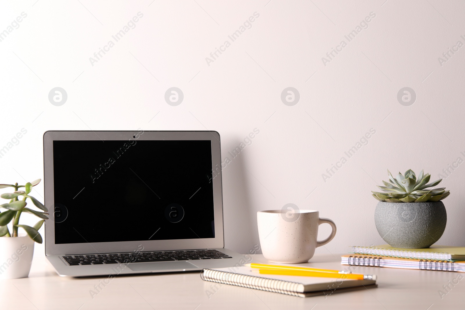 Photo of Modern laptop cup and notebooks on white table