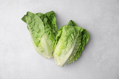 Photo of Fresh green romaine lettuces on light grey table, flat lay