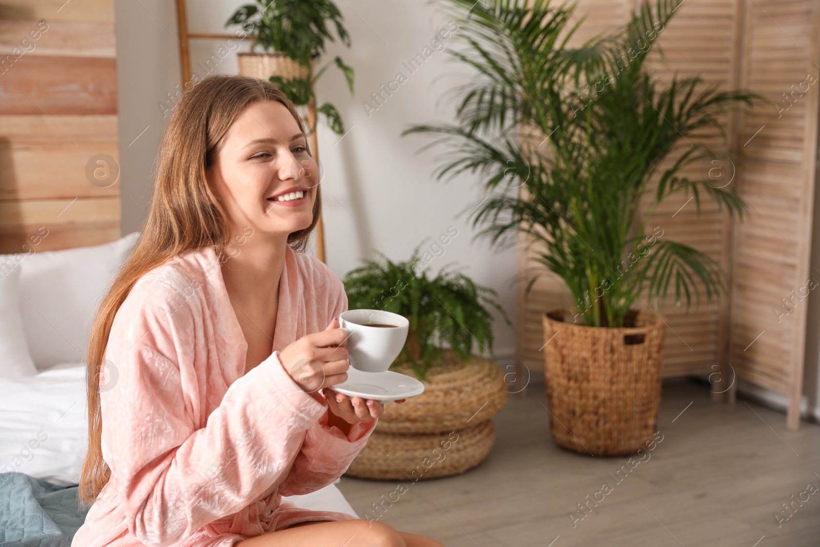 Photo of Woman drinking coffee in bedroom with green plants. Home design ideas