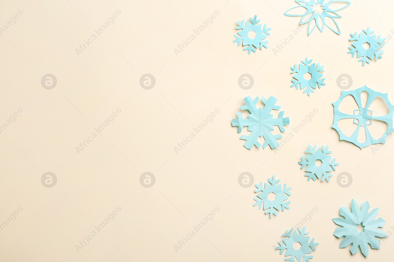 Photo of Many paper snowflakes on light background, flat lay. Space for text