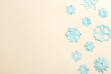 Many paper snowflakes on light background, flat lay. Space for text