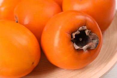 Photo of Delicious ripe persimmons on table, closeup view