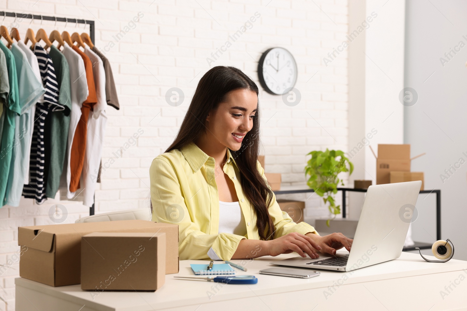 Photo of Seller working with laptop at table in office. Online store