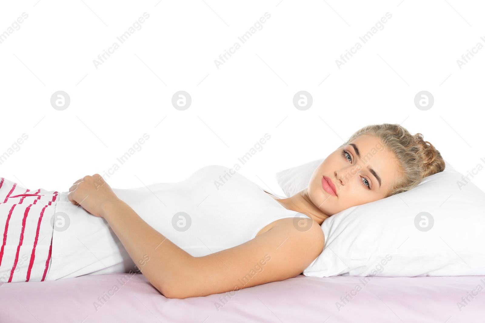 Photo of Beautiful woman lying with comfortable pillow on bed against white background