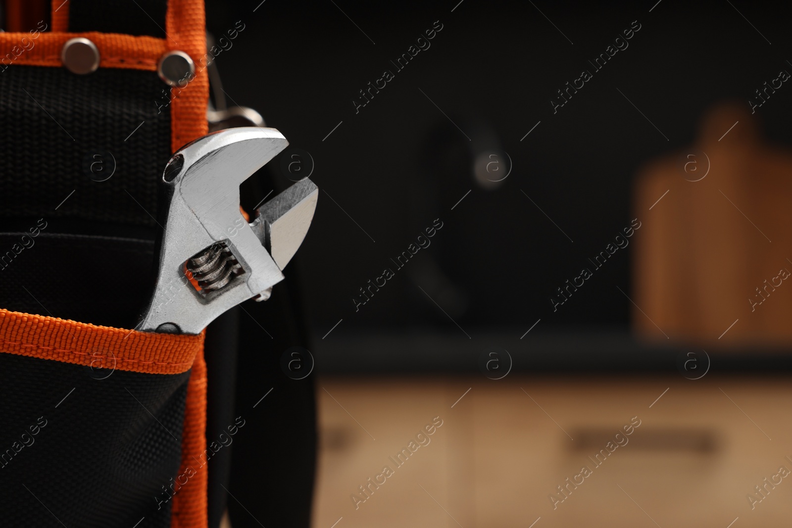 Photo of Plumber's tool bag with adjustable wrench indoors, closeup. Space for text