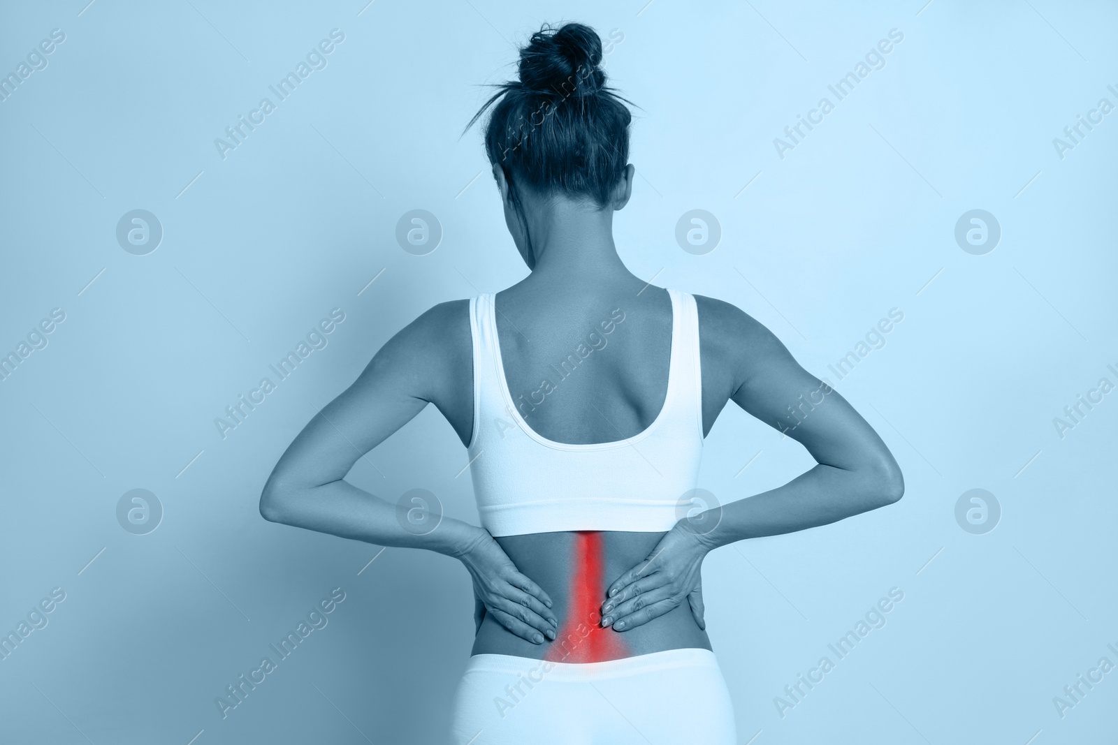 Image of Woman suffering from back pain on color background