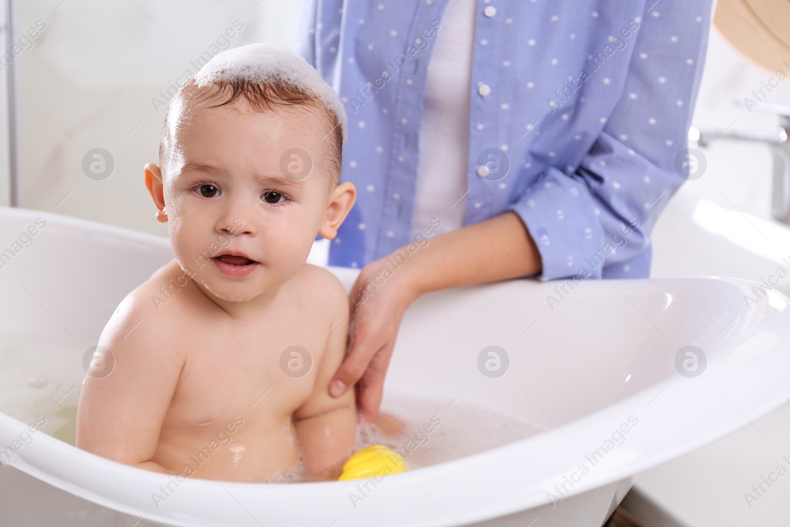 Photo of Mother with her little baby in bathroom