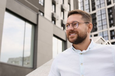 Photo of Portrait of handsome bearded man in glasses outdoors, space for text