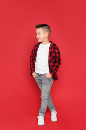 Photo of Full length portrait of cute little boy on red background