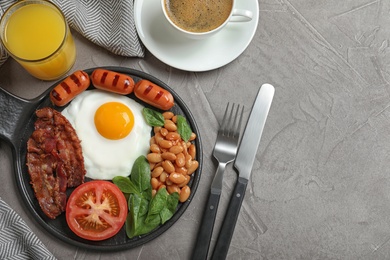 Photo of Delicious breakfast with fried egg served on grey table, flat lay. Space for text