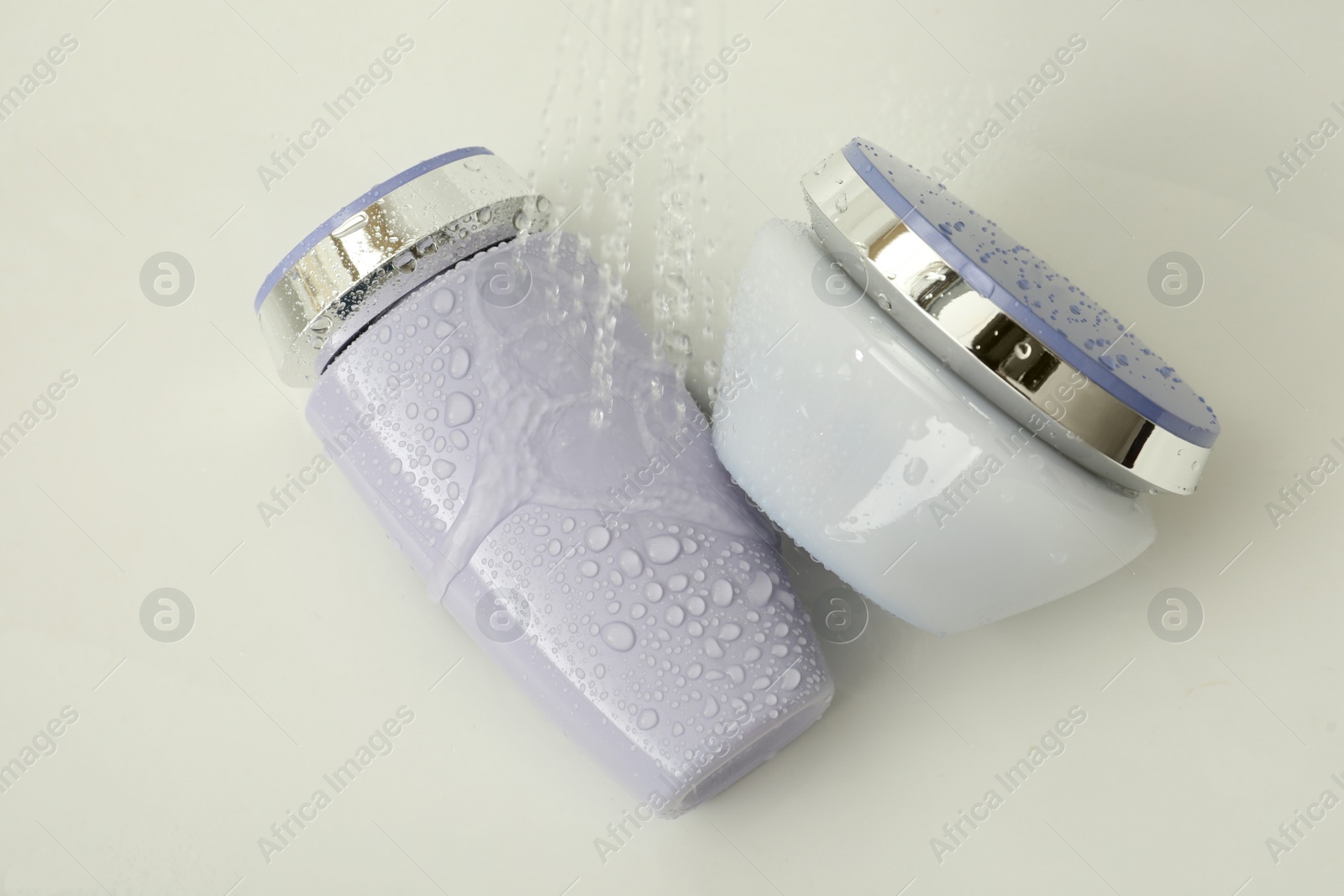 Photo of Hair care cosmetic products under water in sink, above view