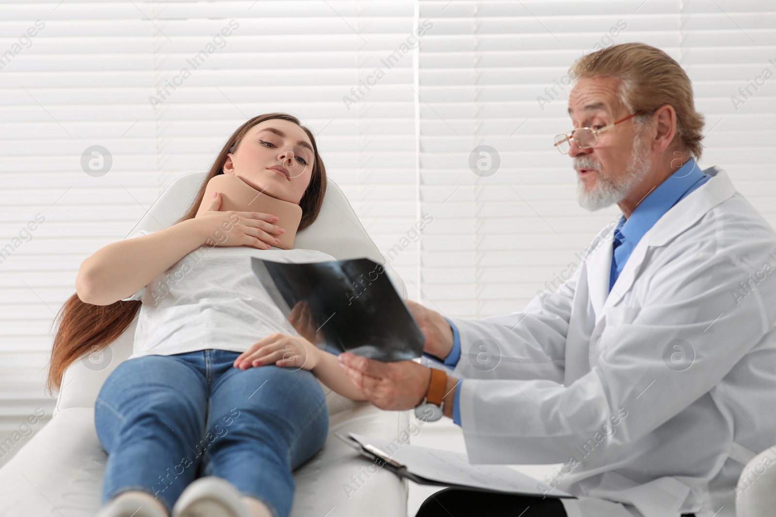 Photo of Orthopedist showing X-ray picture to patient in clinic