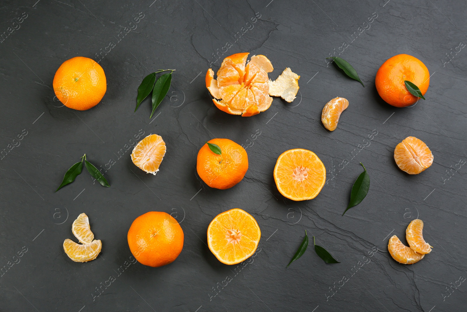 Photo of Flat lay composition with tangerines and different citrus fruits on black background