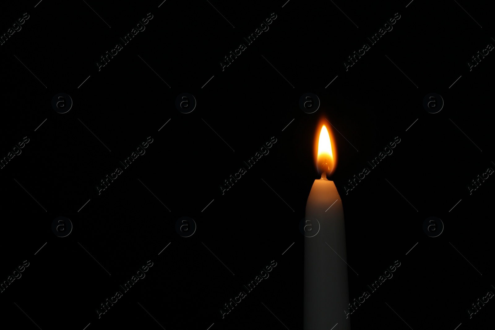 Photo of Burning candle on dark background, space for text. Symbol of sorrow