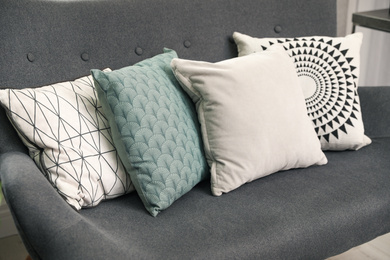 Photo of Stylish decorative pillows on grey couch, closeup