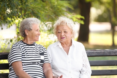 Photo of Elderly women resting on bench in park