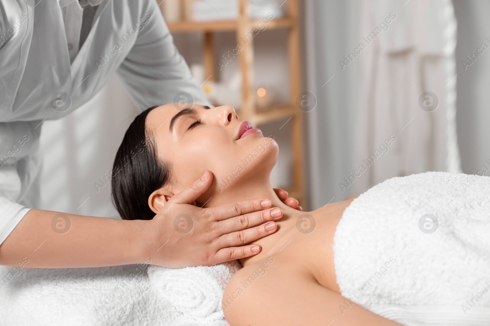 Photo of Beautiful woman receiving massage in beauty salon, closeup