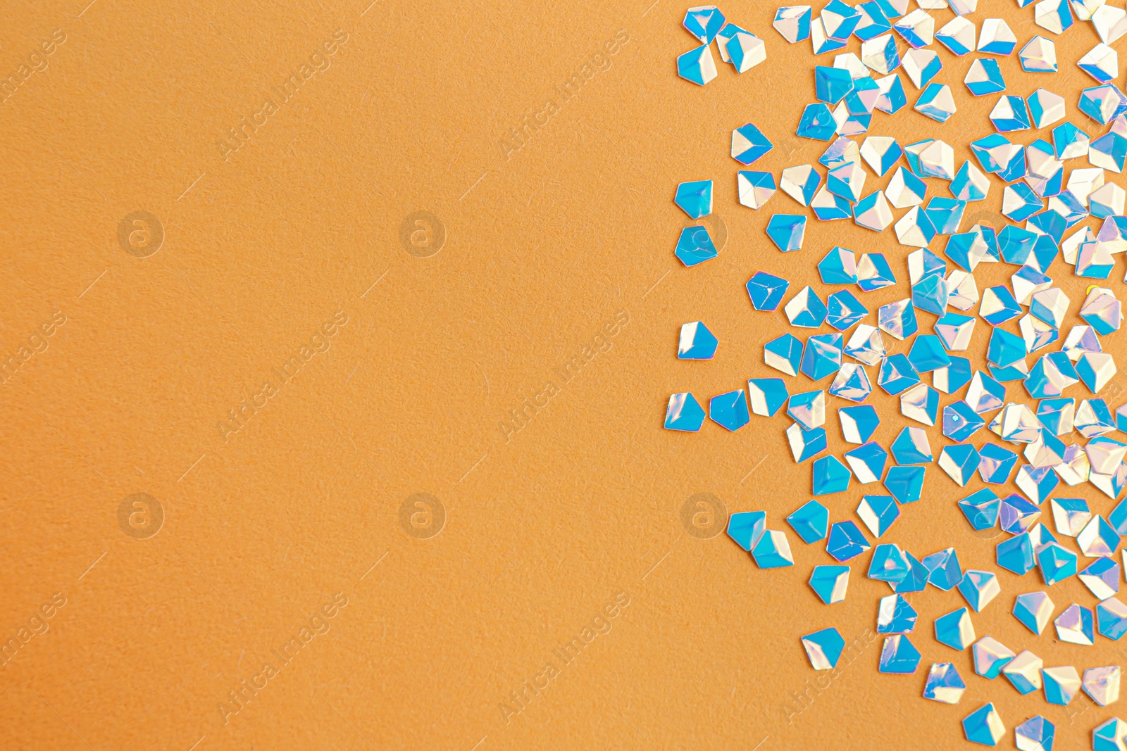 Photo of Shiny bright light blue glitter on beige background, flat lay. Space for text