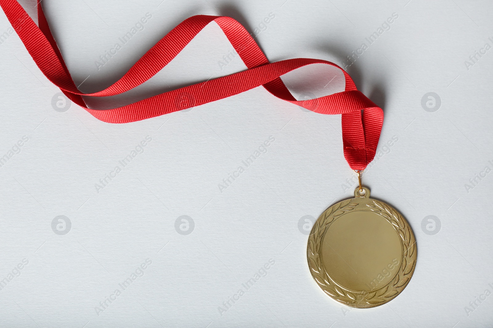 Photo of Gold medal on white background, top view. Space for design