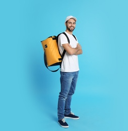 Photo of Young courier with thermo bag on color background. Food delivery service