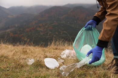 Woman with trash bag collecting garbage in nature, closeup. Space for text