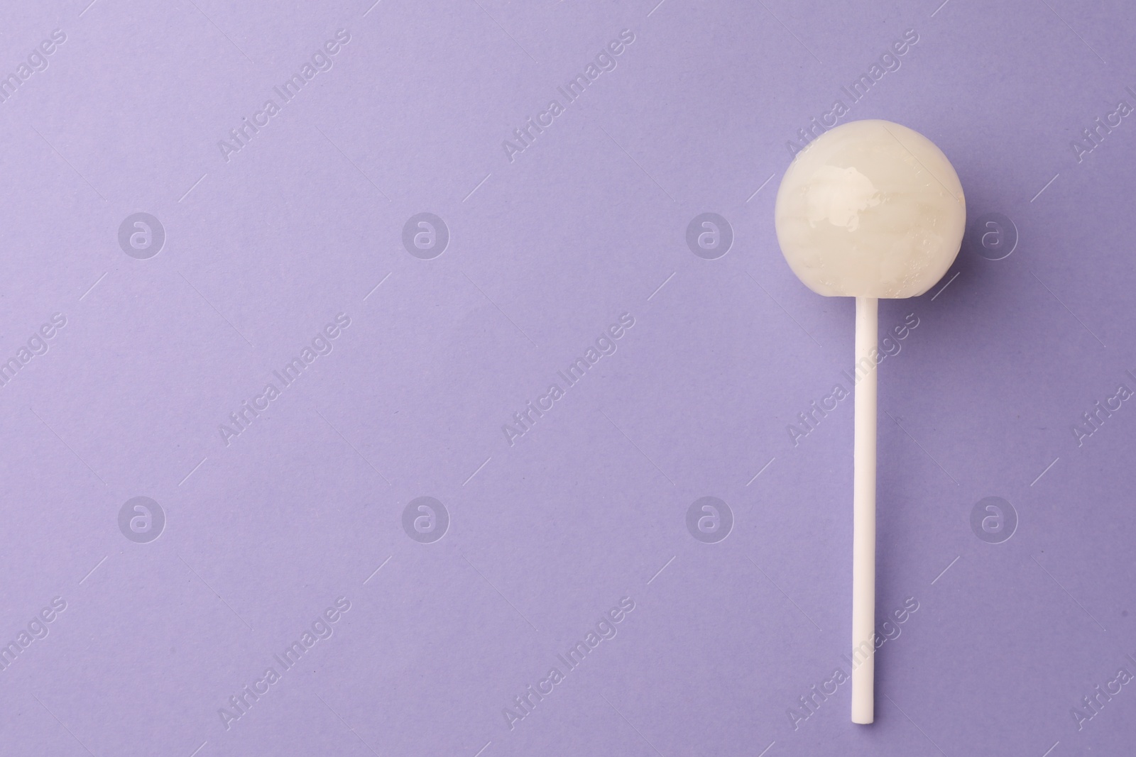 Photo of Tasty lollipop on violet background, top view. Space for text