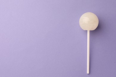 Photo of Tasty lollipop on violet background, top view. Space for text