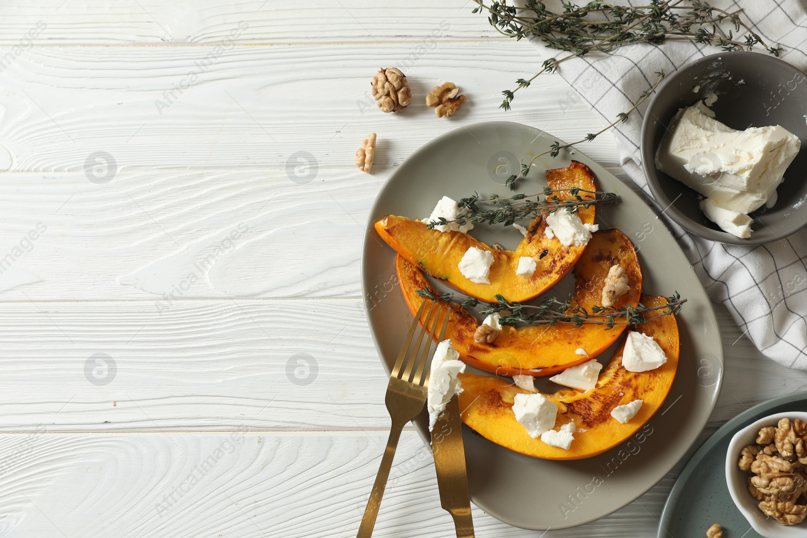 Photo of Delicious pumpkin slices served with thyme and cheese on white wooden table, flat lay. Space for text