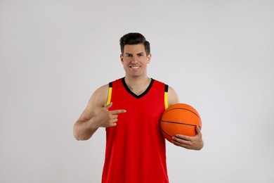 Basketball player with ball on grey background
