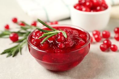 Photo of Cranberry sauce, rosemary and fresh berries on light table