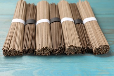 Uncooked buckwheat noodles (soba) on light blue wooden table