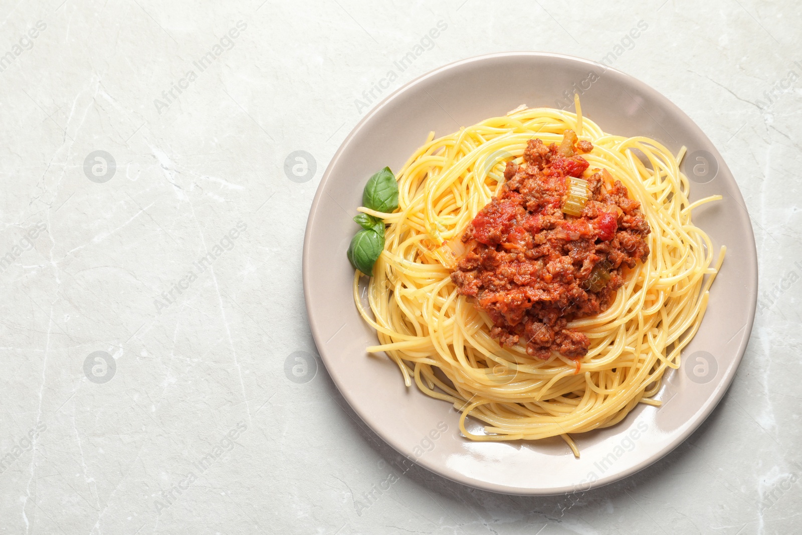 Photo of Plate with delicious pasta bolognese on light background, top view