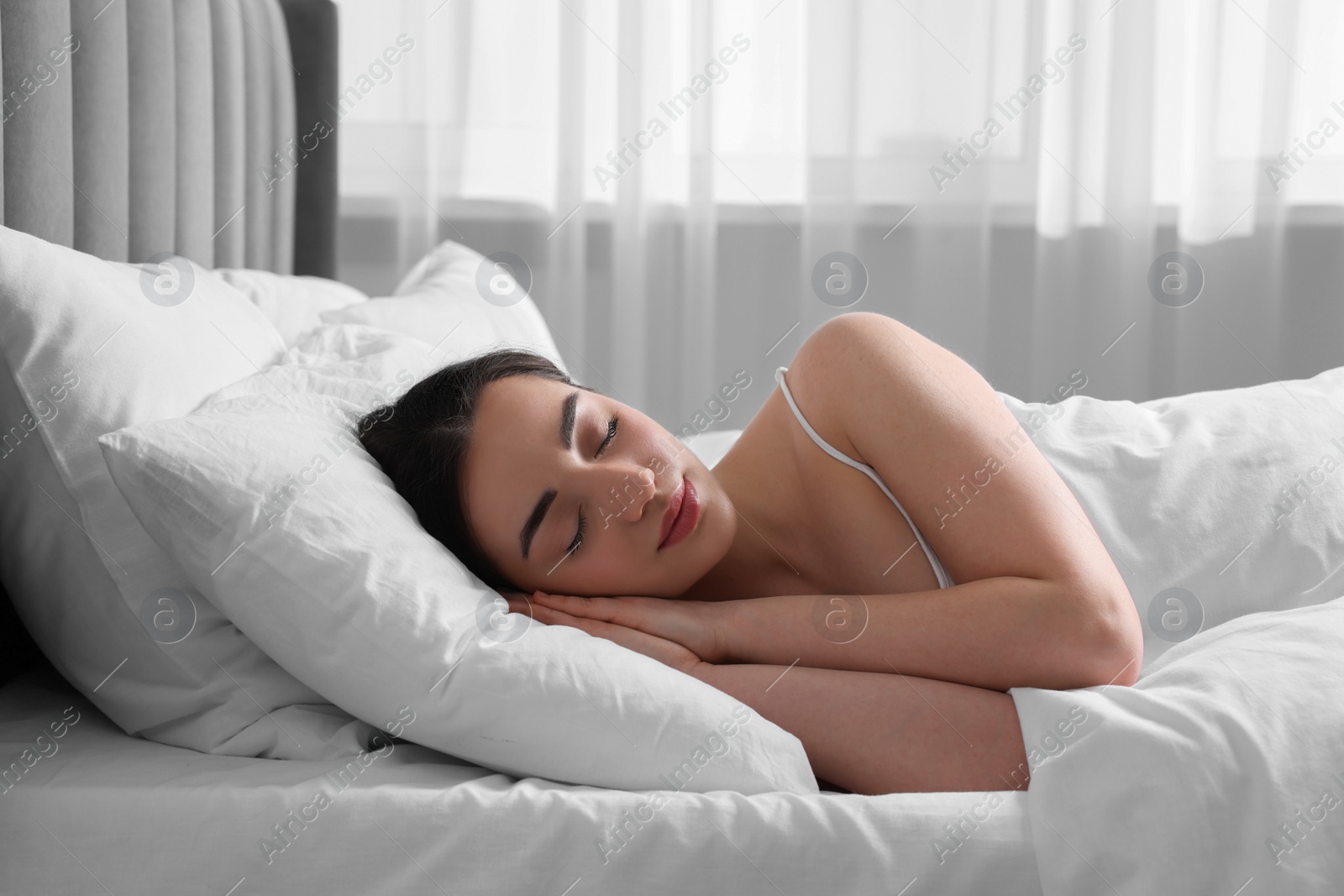 Photo of Beautiful young woman sleeping in soft bed at home