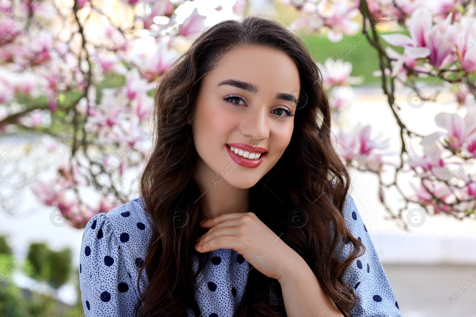 Photo of Beautiful woman near blossoming magnolia tree on spring day