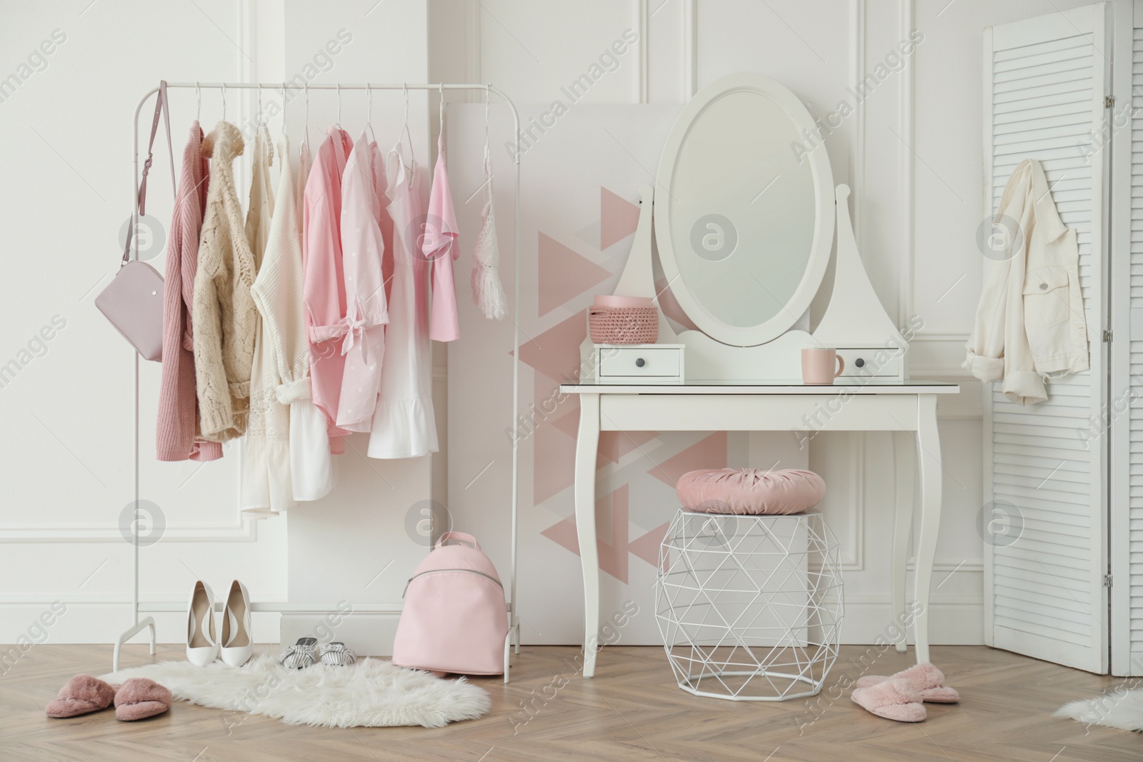 Photo of Dressing room interior with clothing rack and round mirror