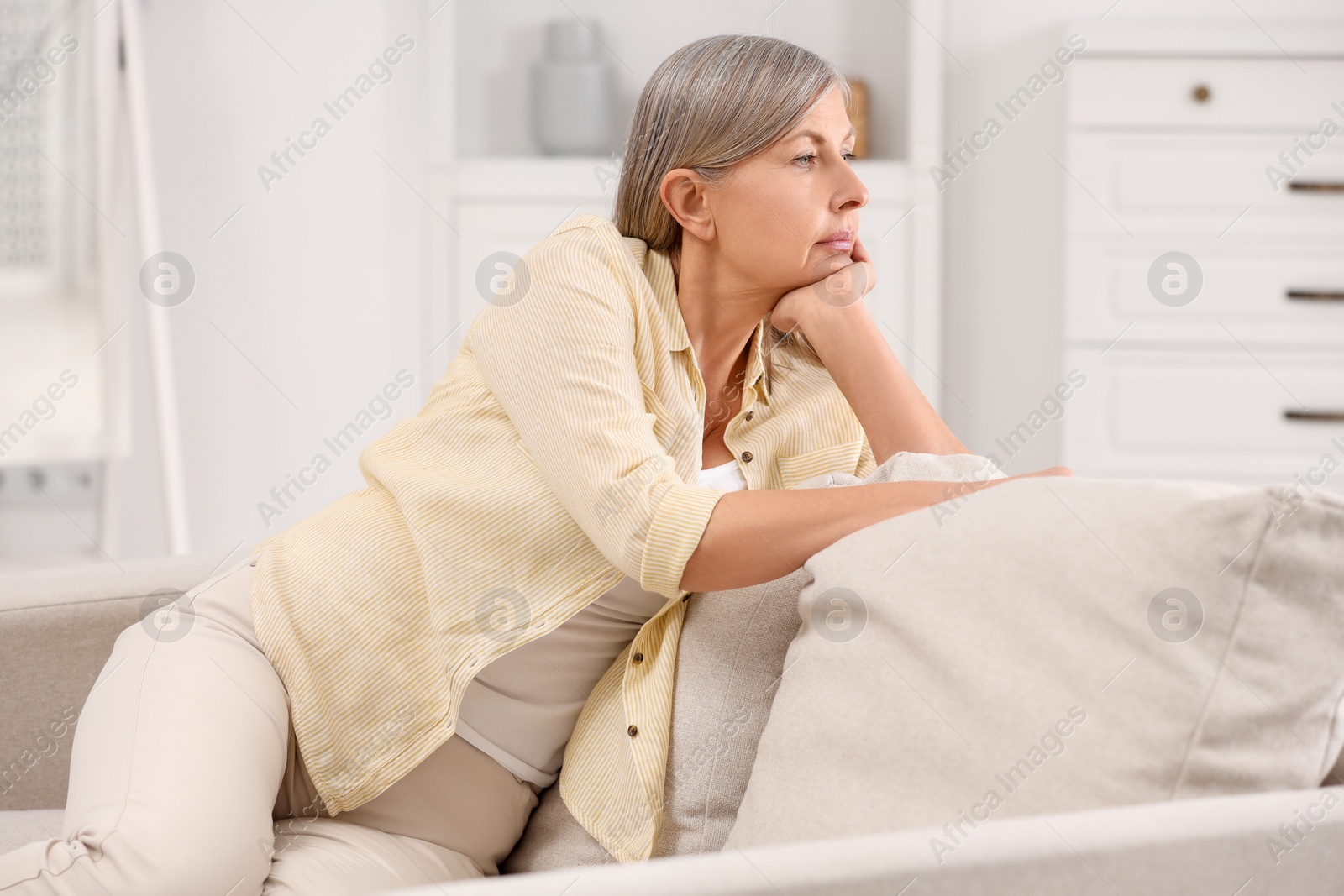 Photo of Menopause, mood changes. Sad woman on sofa at home