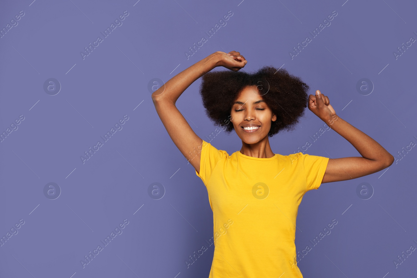 Photo of Portrait of smiling African American woman on purple background. Space for text