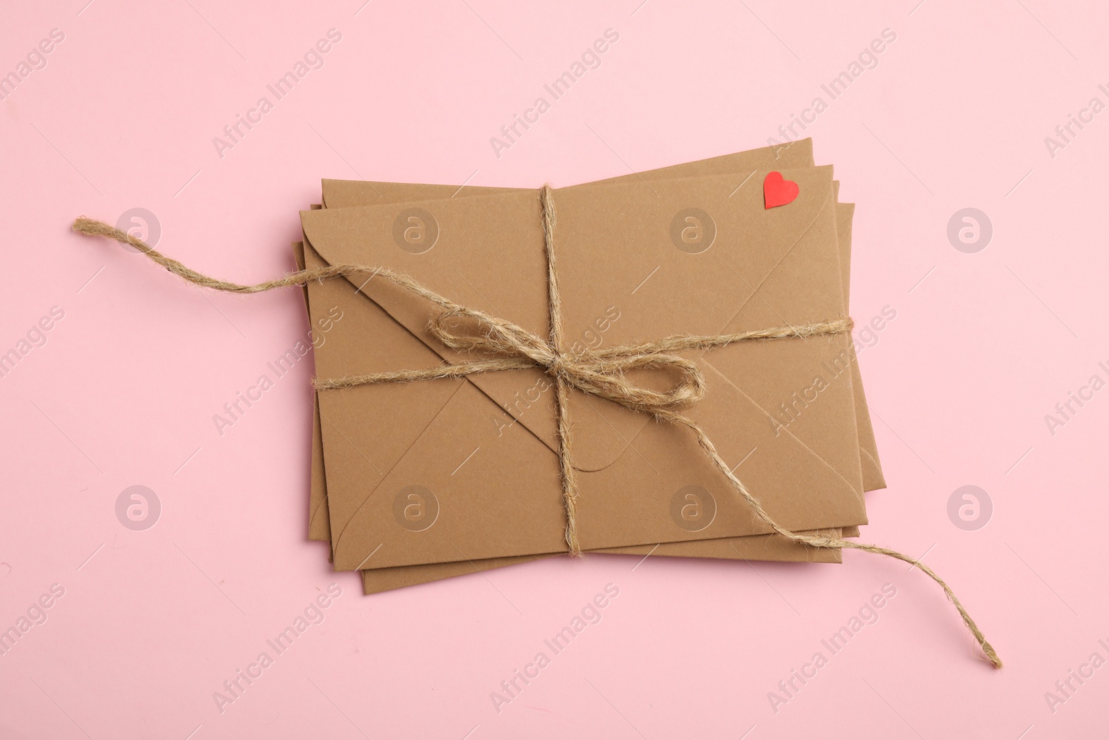 Photo of Stack of envelopes on pink background, top view. Love letters