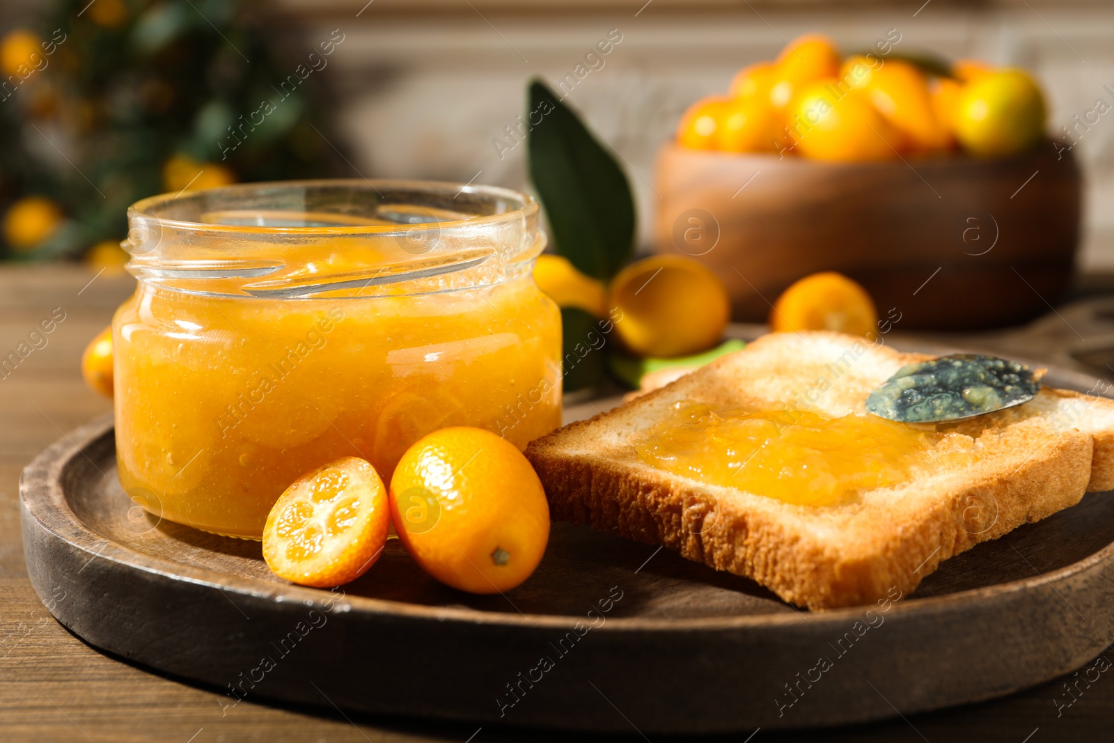 Photo of Delicious kumquat jam and sandwich on wooden table
