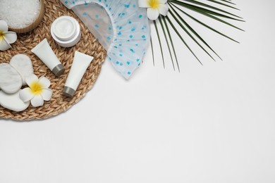 Photo of Flat lay composition with shower cap and toiletries on white background. Space for text