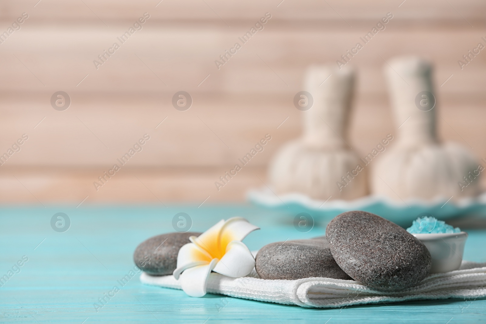 Photo of Composition with spa stones on wooden table. Space for text