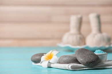 Photo of Composition with spa stones on wooden table. Space for text