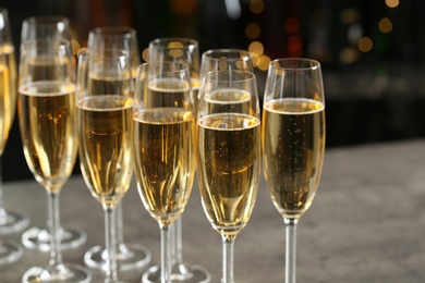 Photo of Glasses of champagne on table against blurred background