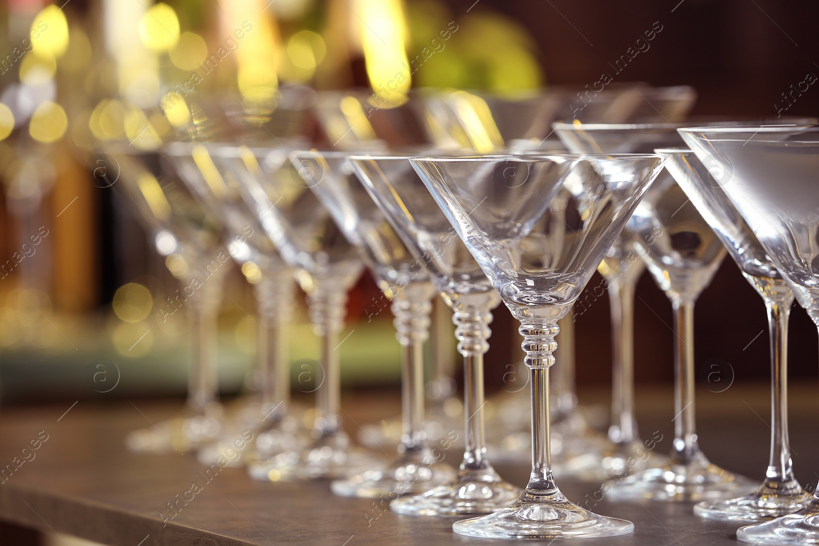 Photo of Empty martini glasses on table against blurred background