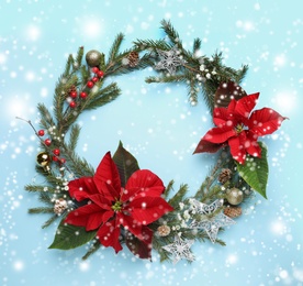 Flat lay composition with traditional Christmas poinsettia flowers and space for text on light blue background. Snowfall effect