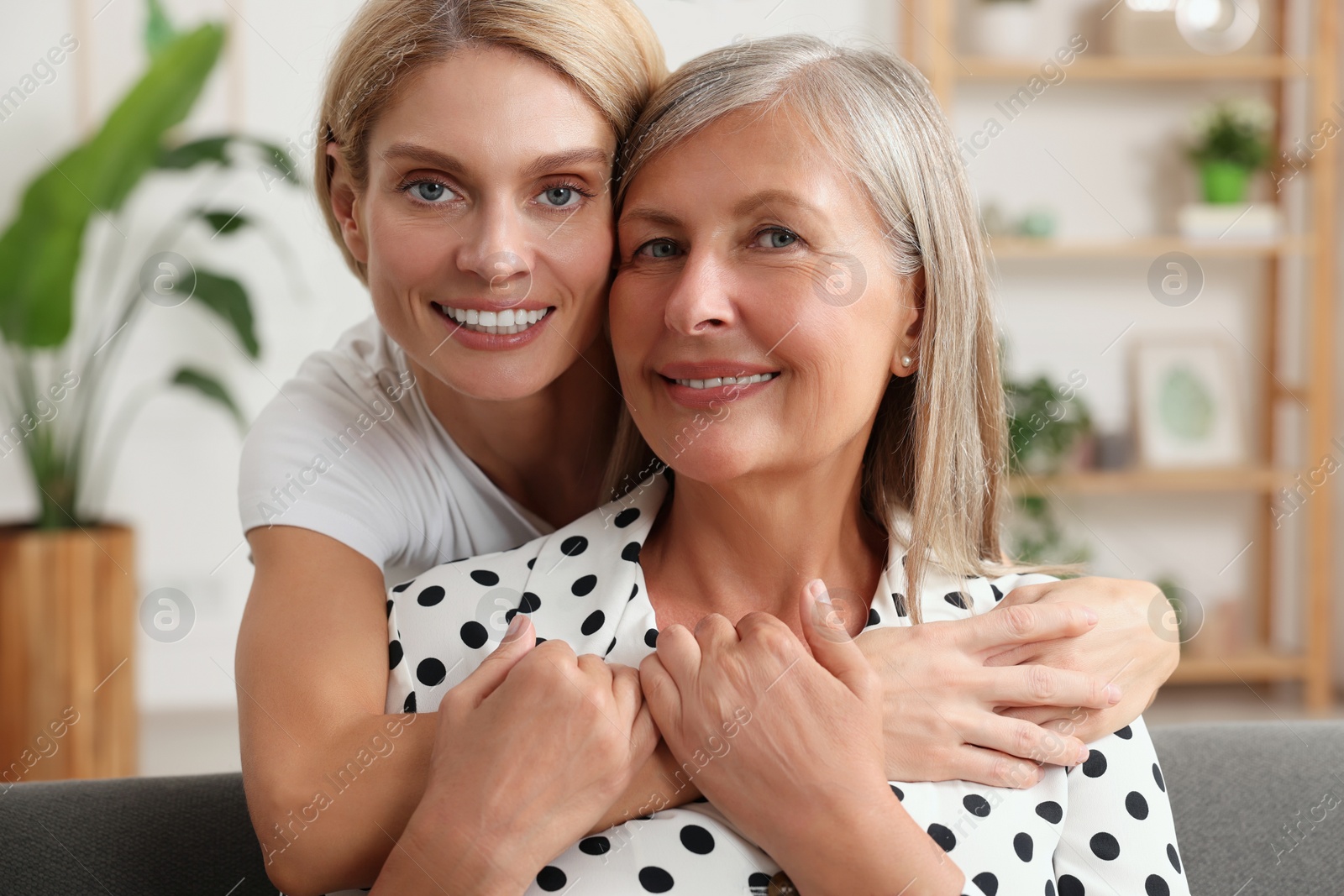 Photo of Happy mature mother and her daughter hugging at home