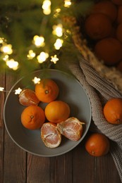 Fresh ripe tangerines and Christmas decor on wooden table, flat lay